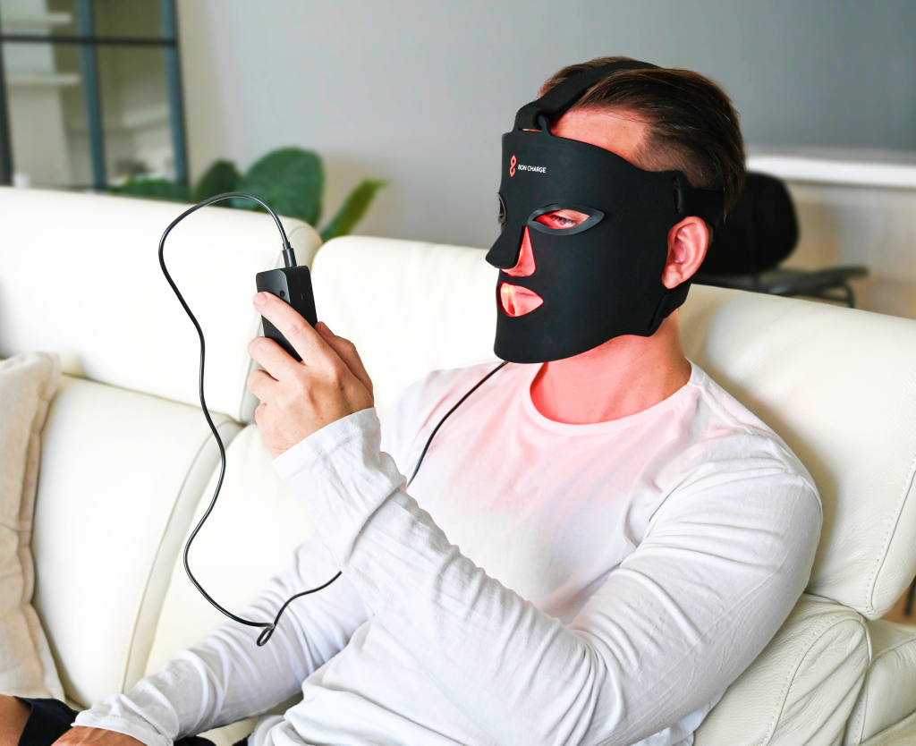 Man Using Controller On Red Light Face Mask