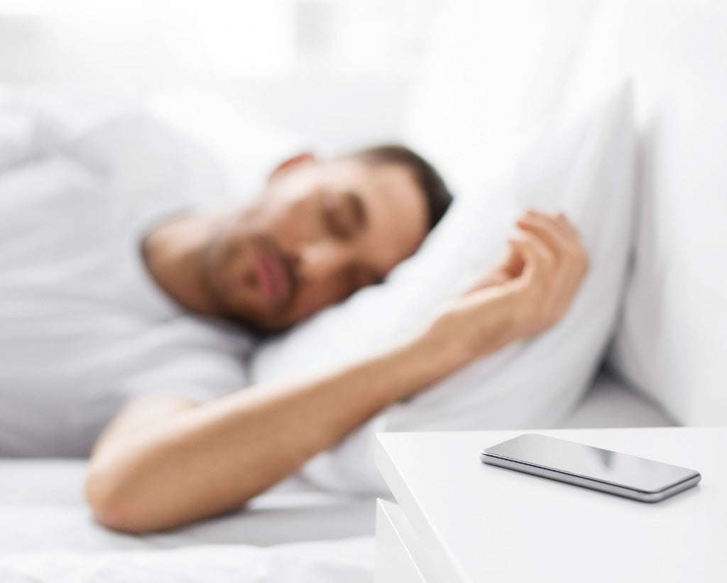 Man With Hand On Pillow Asleep Next To Phone